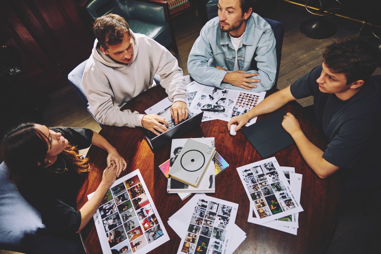 Editorial planning session with printed layouts on the table