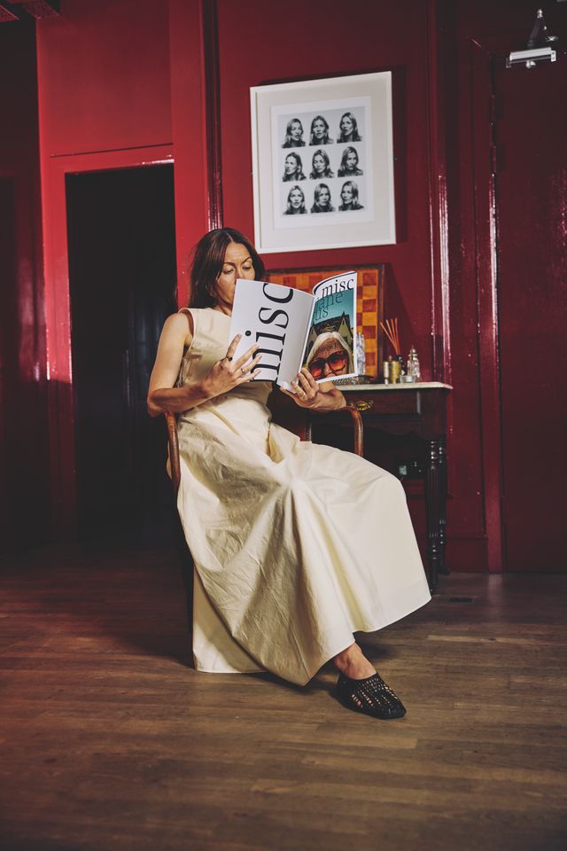 Reader with the printed Misc magazine in a deep red interior